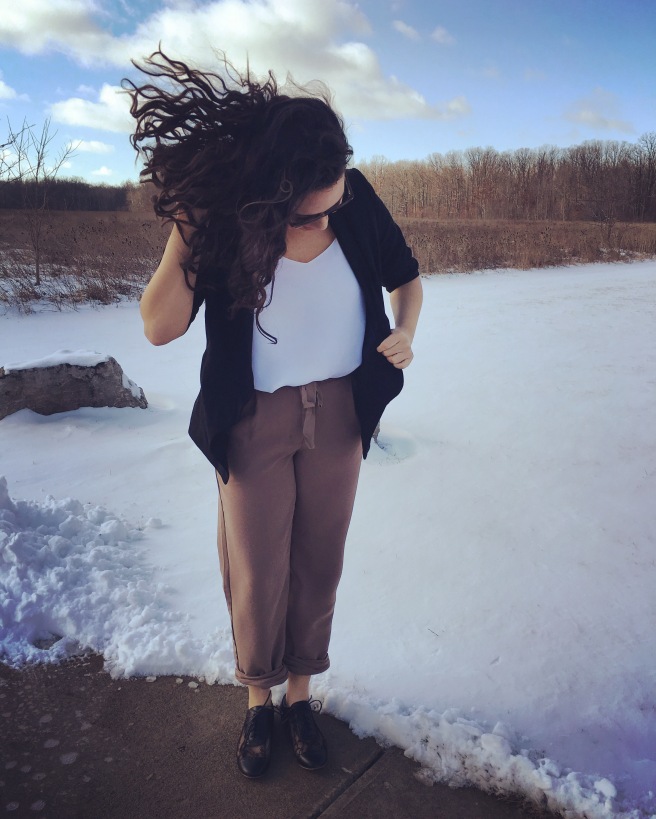 A girl standing outside in the snow flipping her hair